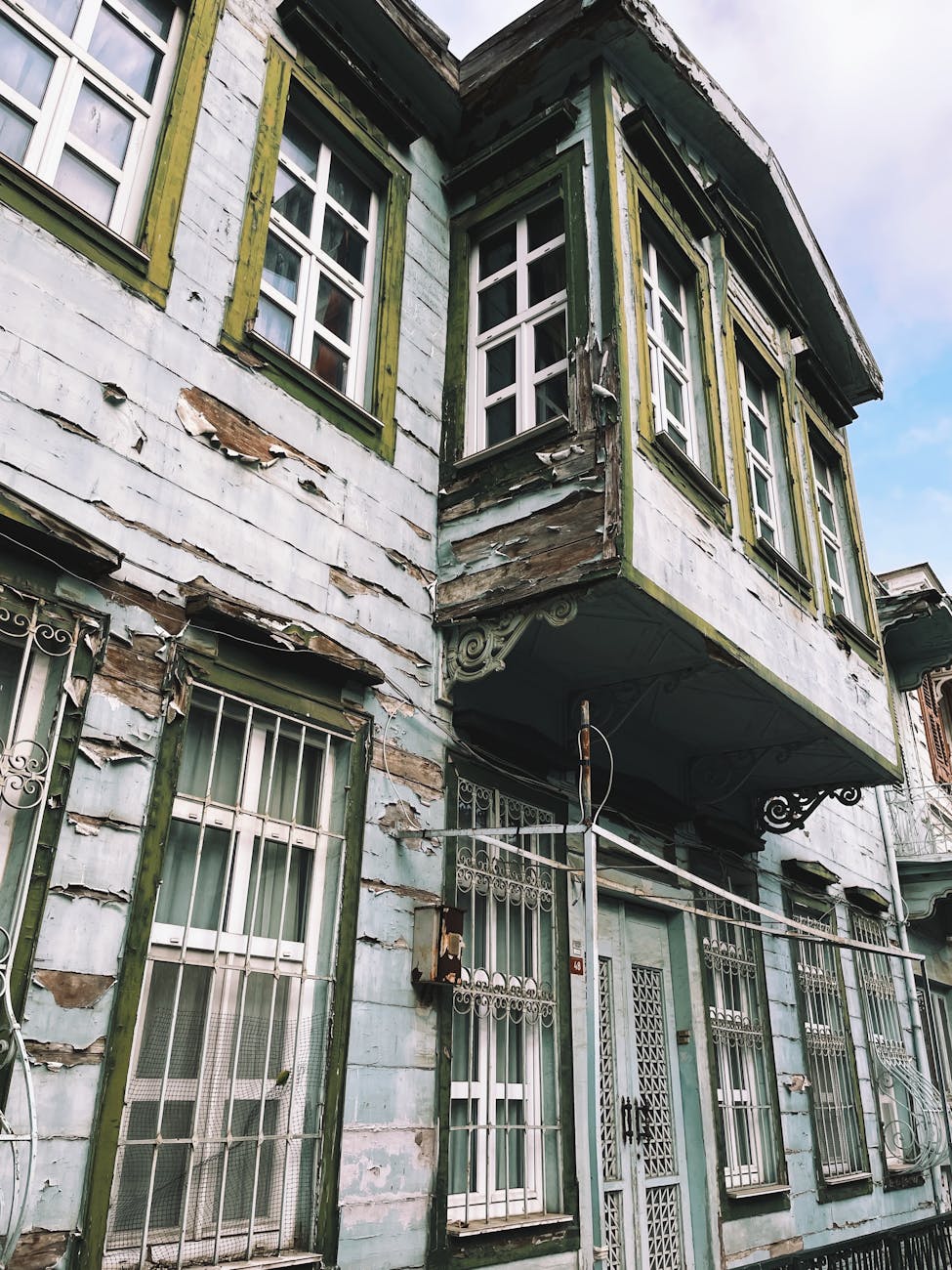 historic weathered building with green trim in urban setting