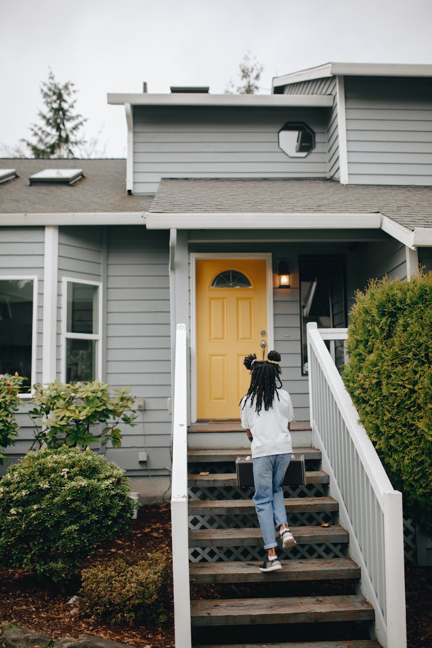 a girl walking up stairs to house's front door